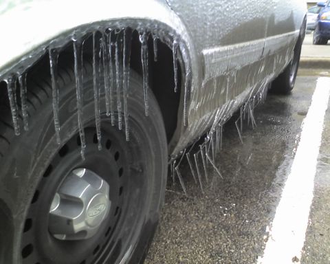 2000 Ford Crown Victoria - Icicles hang from the wheel well and lower body panels of a 2000 Ford Crown Victoria after an ice storm.