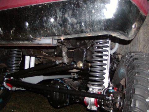 1991 Ford Bronco - Close-up view of a vehicle's modified suspension system, prominent coil springs and steering linkage.