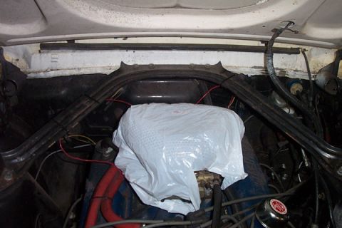 1968 Ford Mustang - The engine bay of a 1968 Ford Mustang shows the carburetor covered for protection.
