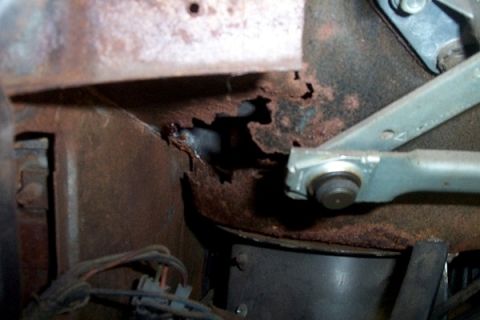 1968 Ford Mustang - Significant rust damage is visible on this vehicle's body panel, obscuring any specific model year identification.