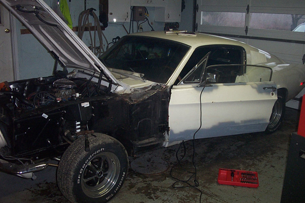 1968 Ford Mustang coupe, white, in garage with hood open, front fender removed, bodywork in progress