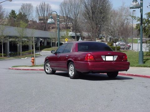 2002 Ford Crown Victoria - Rear view of a red 2002 Ford Crown Victoria parked on a street.