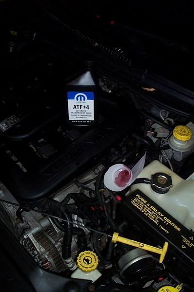 1999 Chrysler 300M - Transmission fluid change in progress, showing the engine bay and necessary supplies.
