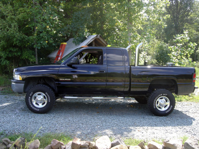 2002 Dodge 2500 - This black Dodge Ram 2500 pickup truck is parked outdoors on a gravel surface.