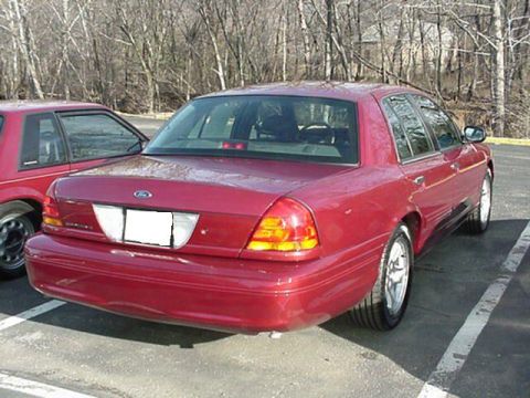 2002 Ford Crown Victoria - Rear view of a red 2002 Ford Crown Victoria sedan parked in a lot.
