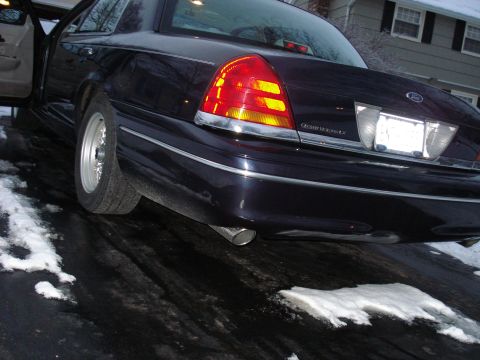 2000 Ford Crown Victoria - The rear of a dark blue Ford Crown Victoria is shown with the driver's door ajar.