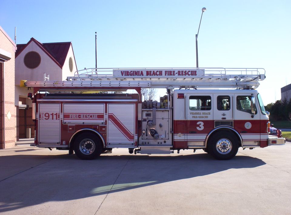 Side view of a red and white Virginia Beach Fire-Rescue truck with ladder