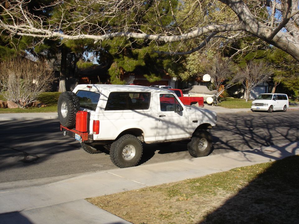 White 1996 Ford Bronco with spare tire and red jerry can on rear bumper