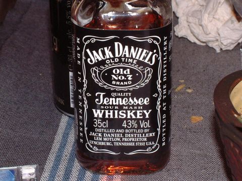 1989 Ford Bronco - A bottle of Jack Daniel's Tennessee whiskey sits on a textured surface next to a dark can.