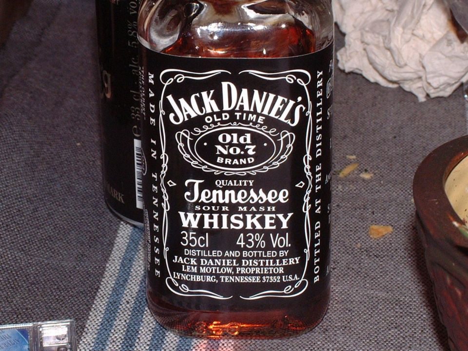 Jack Daniel's whiskey bottle with black label, showing text and amber liquid
