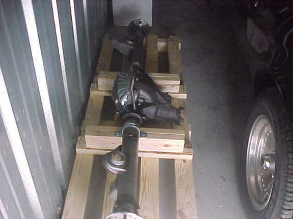 Rear axle and driveshaft assembly on wood pallets in a metal storage unit