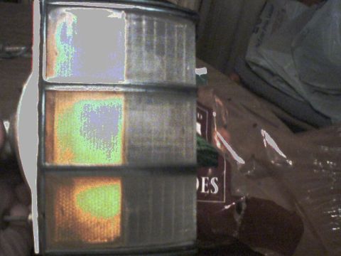 1973 Ford Ranchero - A close-up of a vehicle's taillight assembly, with visible text on a background object.