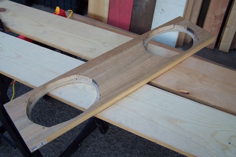 Wooden mount with two circular cutouts for speakers, resting on sawhorses