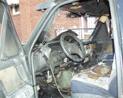 1989 Ford Bronco - The interior of a severely damaged vehicle shows extensive fire damage to the dashboard, seats, and roof.