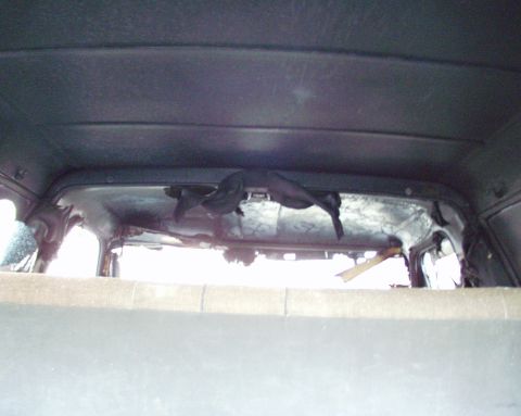 1989 Ford Bronco - The interior of the vehicle shows significant damage to the headliner and rear window frame.