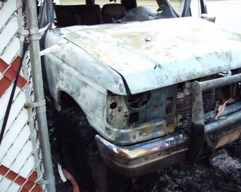 1989 Ford Bronco - This 1989 Ford Bronco shows extensive fire damage, with its front end and grille guard partially visible.