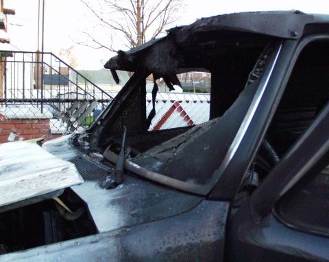 1989 Ford Bronco - Interior of a vehicle heavily damaged by fire, with the roof and dashboard charred and melted.