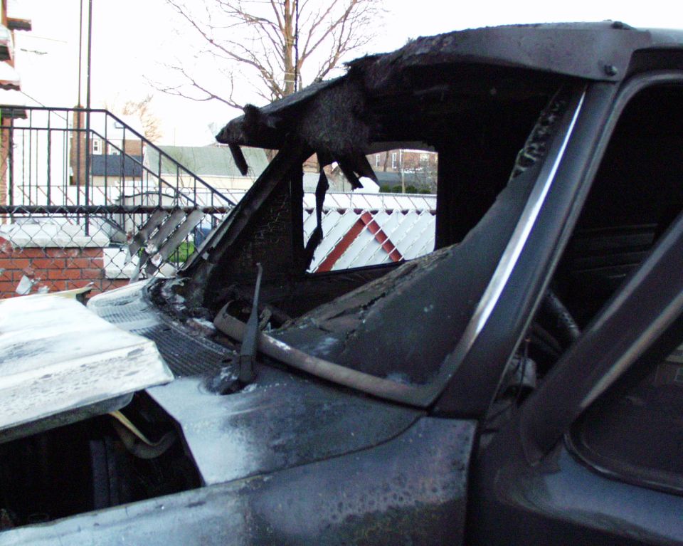 Burned out vehicle interior, showing melted dashboard and roof structure. Supermotors.net logo visible