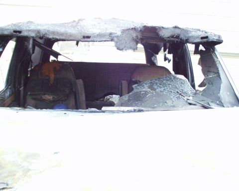 1989 Ford Bronco - The interior of the vehicle is heavily damaged from a fire, with melted materials and broken glass visible.