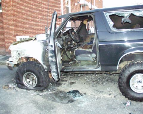 1989 Ford Bronco - This heavily damaged 1989 Ford Bronco shows extensive fire damage, with its interior exposed and windows shattered.