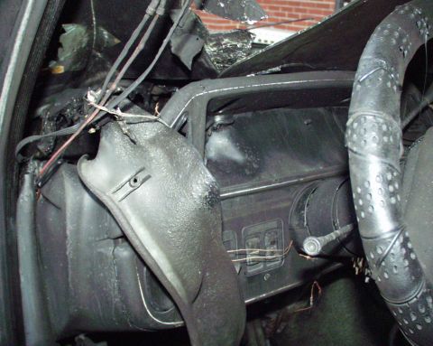 1989 Ford Bronco - Interior of a vehicle heavily damaged by fire, with melted components visible.