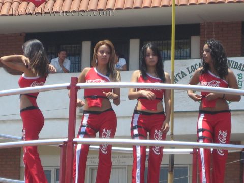 1990 Ford Bronco - Four promotional models in red Coca-Cola crop tops and pants stand behind a railing before a brick building.