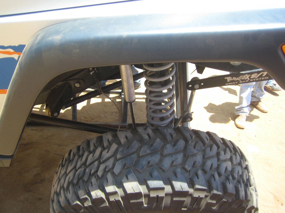 Close-up of off-road vehicle suspension with coilover shock and large mud tire