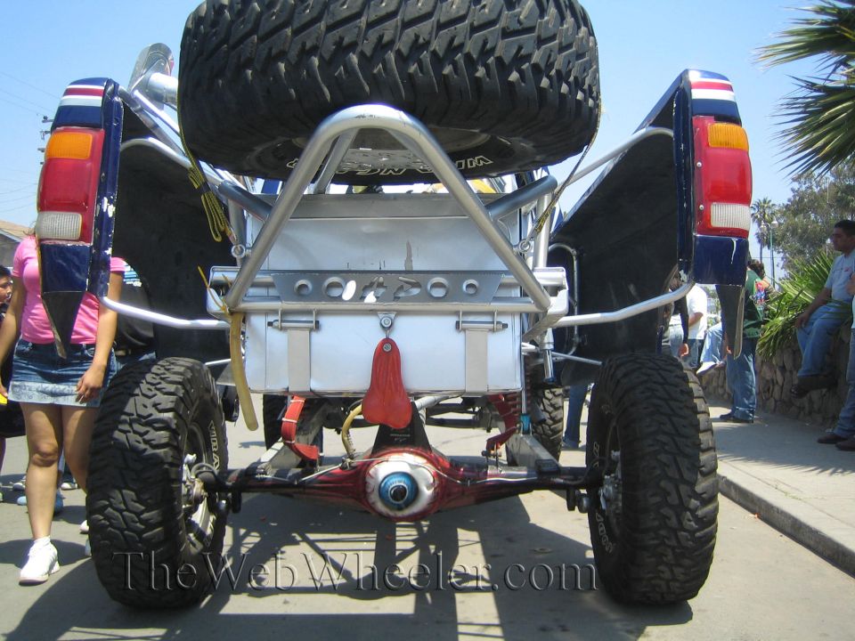 Rear view of a lifted off-road vehicle showing chrome rear cage and spare tire