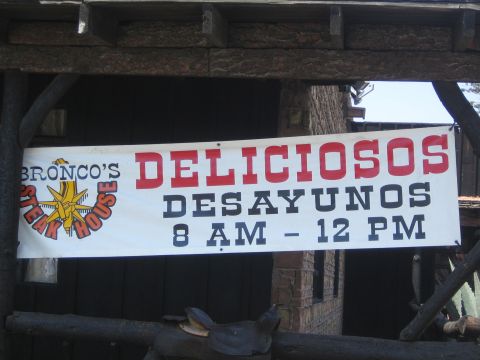1990 Ford Bronco - Photo of a Bronco's Steak House banner advertising 'Deliciosos Desayunos 8 AM - 12 PM'.