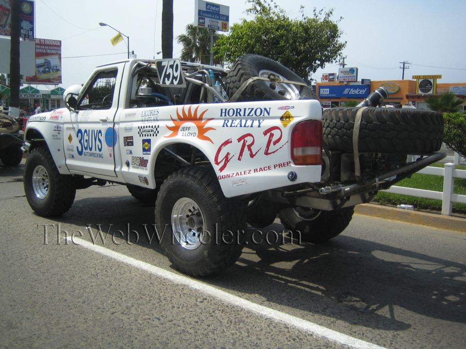 Rear of white Ford race truck 759 with GRP Horizon Realty graphics and spare tires