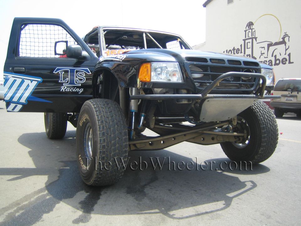 Front of black LS Racing prerunner pickup with tube bumper and long-travel suspension, door open