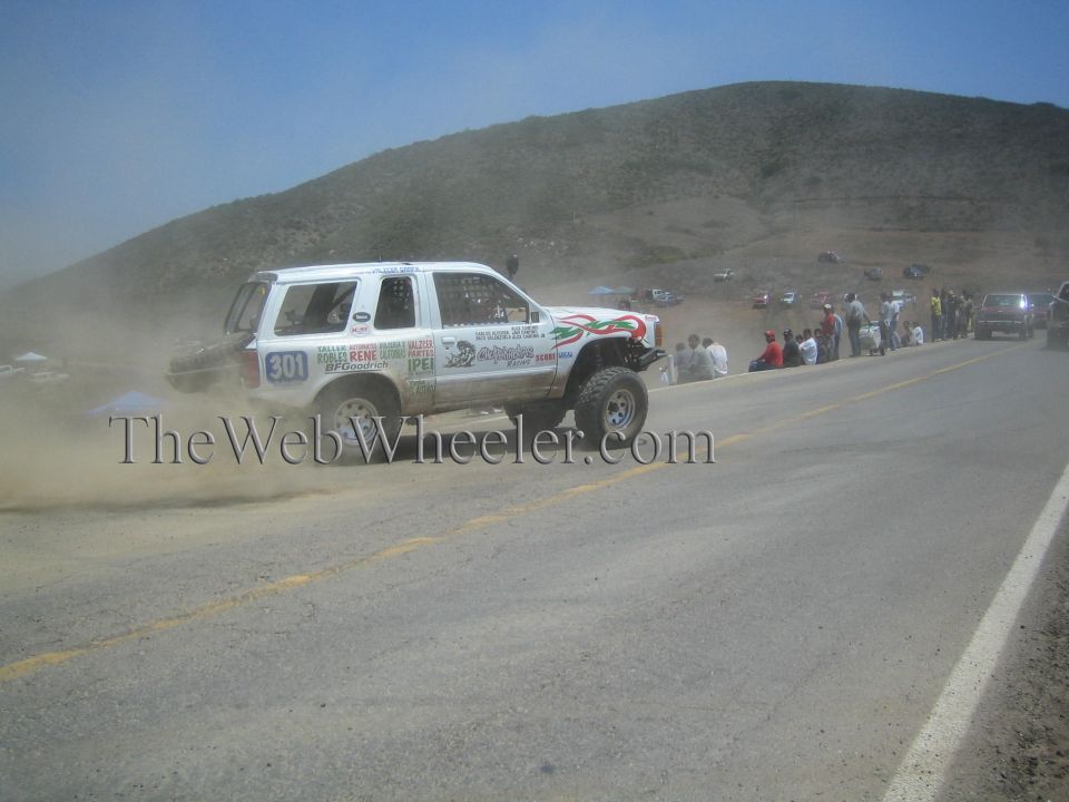 White number 301 race SUV with tricolor stripes drifting on a hillside road