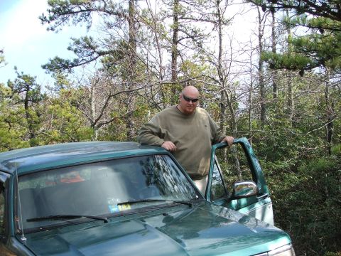 1996 Ford Bronco - Man poses with a green 1996 Ford Bronco in a wooded area.