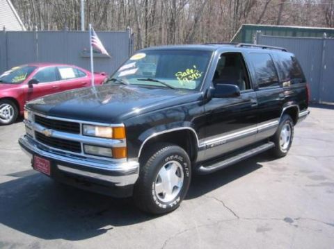 1998 Chevrolet Tahoe - This black 1998 Chevrolet Tahoe is shown from a 3/4 front angle, with a sale price visible on the windshield.