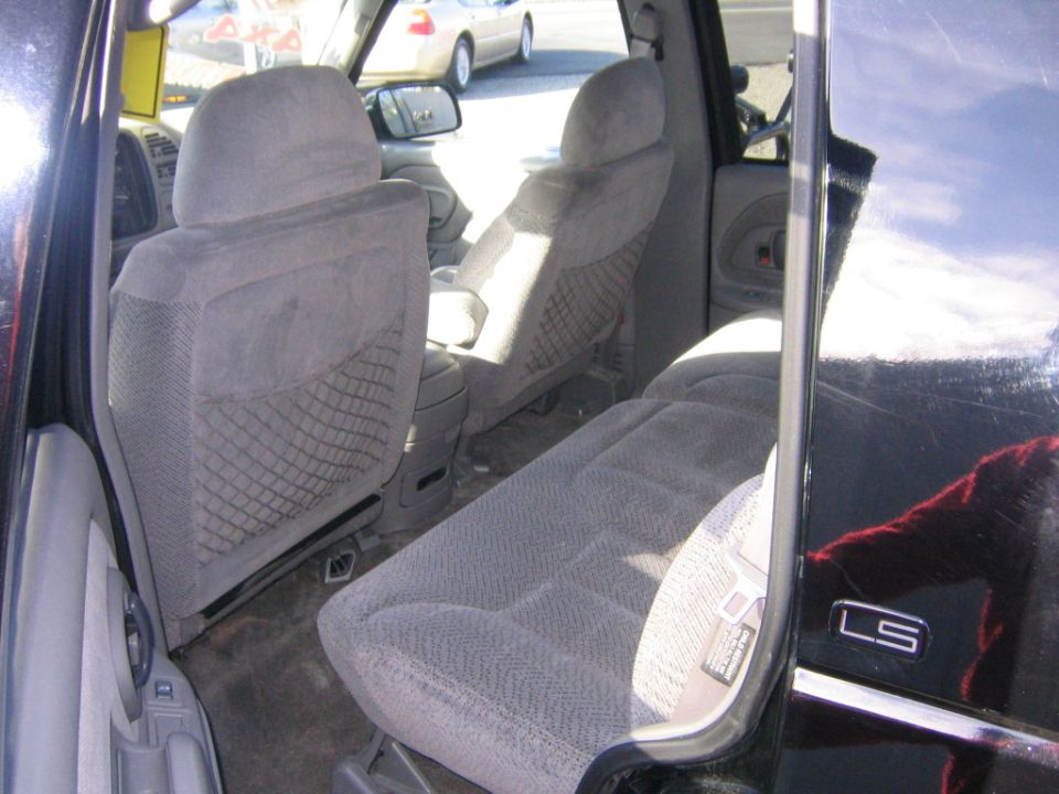 Black SUV interior with gray cloth seats, LS badge visible on the door