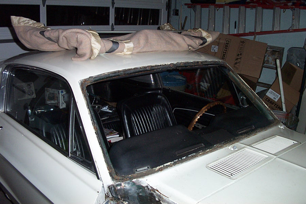 1968 Ford Mustang coupe with windshield removed, interior visible, covered roof