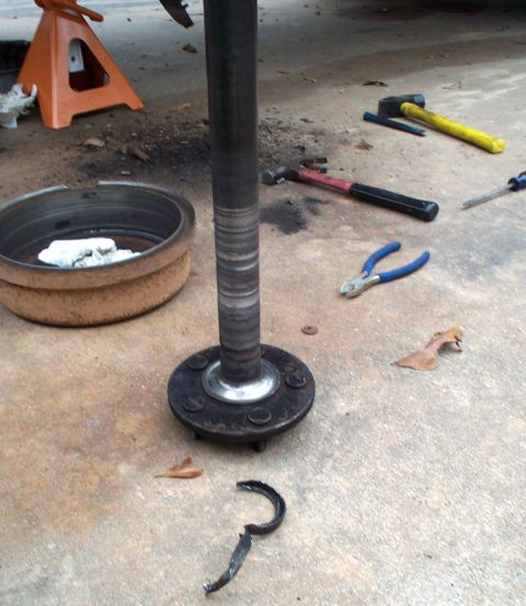 1978 Dodge Power Ram - Axle shaft and brake drum removed from vehicle, with tools nearby for repair.