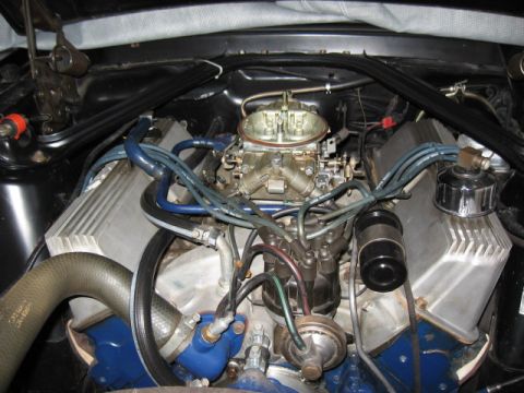 1968 Shelby GT500 - The engine bay of a 1968 Shelby GT500 shows a V8 engine with aftermarket aluminum valve covers and a Holley carburetor.