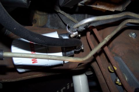 1990 Ford Bronco - A white transmission filter with red lettering is visible, connected by hoses and clamps.