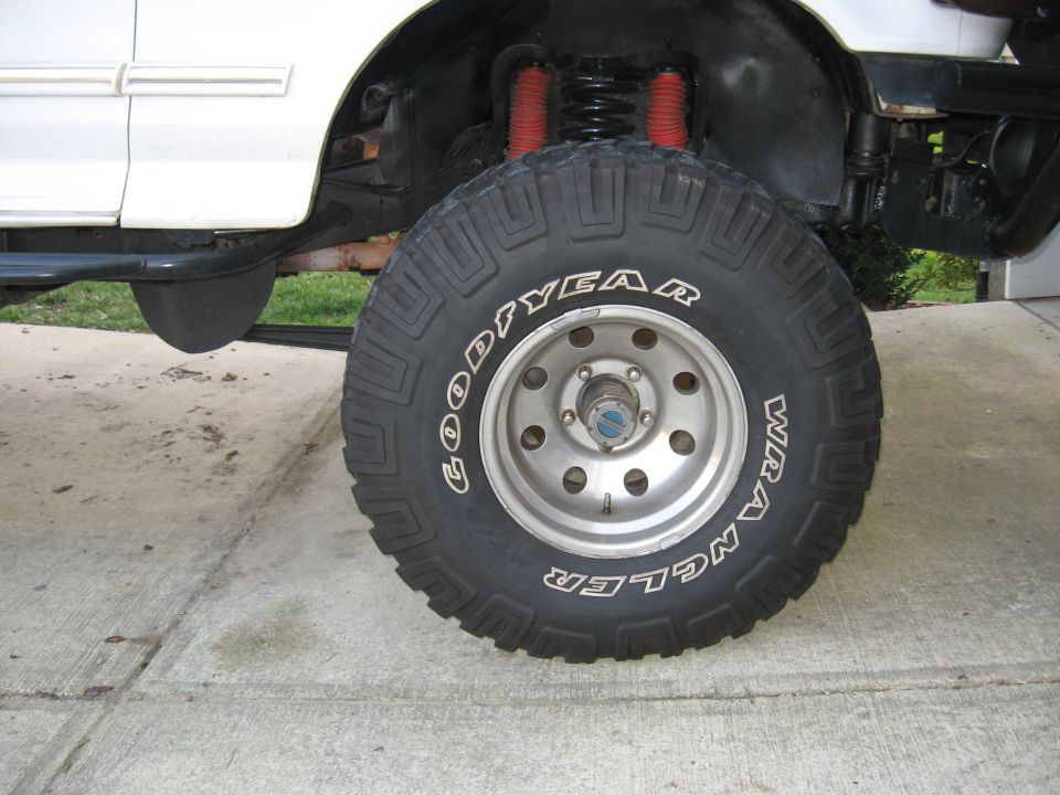 Goodyear Wrangler MT/R tire on 8-slot alloy wheel with locking hub on a white Ford 4x4