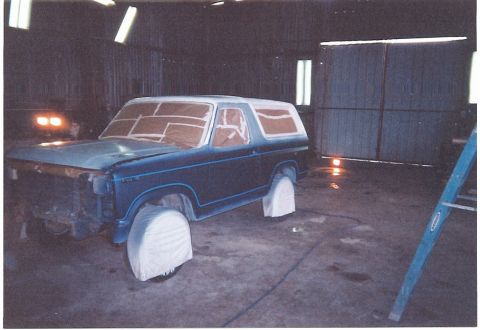 1981 Ford Bronco - Ford Bronco in a workshop, prepped for paint with windows taped off.