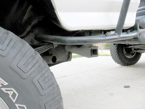 1996 Ford Bronco - The rear of a white 1996 Ford Bronco shows a hitch receiver and spare tire.