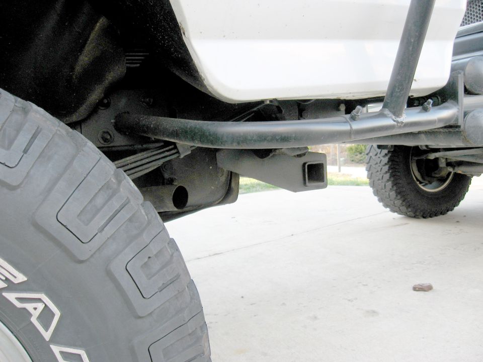 White 1996 Ford Bronco rear bumper with a black hitch receiver and spare tire visible