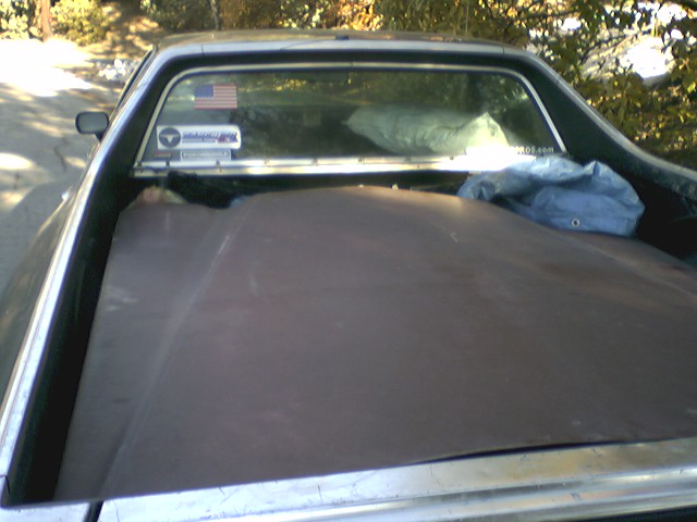 Pickup truck bed with cover, American flag sticker on rear window