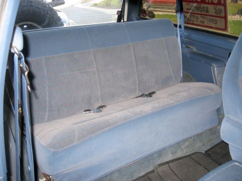 1996 Ford Bronco - Interior view of a vehicle's rear bench seat with blue fabric upholstery and seatbelts.