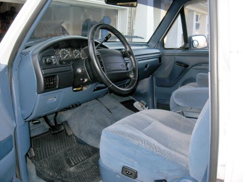 1996 Ford Bronco - The interior of this 1996 Ford Bronco features blue cloth seats and a matching dashboard with visible gauges.