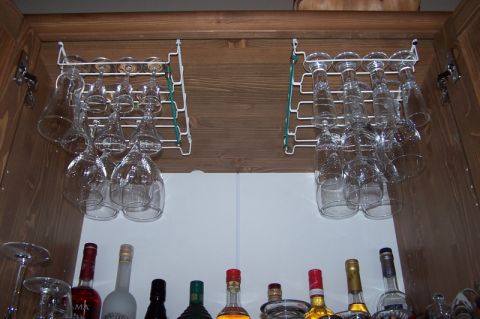 1990 Ford Bronco - A cabinet displays various wine glasses and bottles of liquor on wooden shelves.