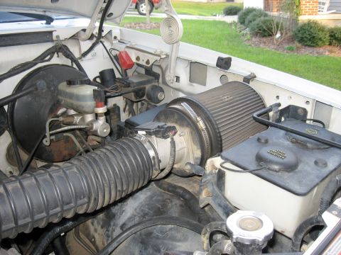 1996 Ford Bronco - Engine bay of a 1996 Ford Bronco, an aftermarket air intake and visible brake components.
