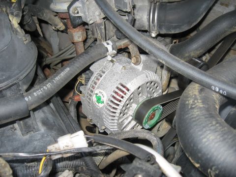 1996 Ford Bronco - Engine bay detail showing the alternator and associated hoses and wiring. The "Mean Green" sticker is visible on the alternator housing.
