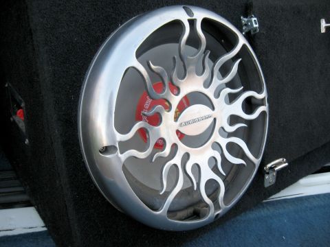 1996 Ford Bronco - Custom car audio subwoofer with a distinctive flame design on its protective grille.